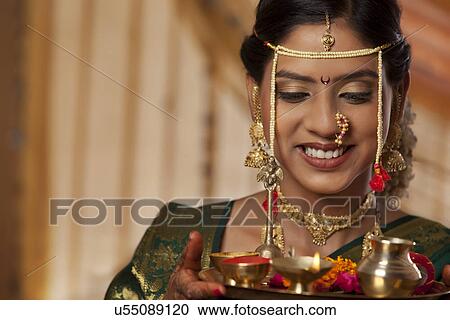 Stock Image - Beautiful young bride smiling with offerings . Fotosearch