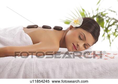 Beautiful young woman getting hot stone treatment View Large Photo Image Stock Photography - Beautiful young woman getting hot stone treatment . Fotosearch