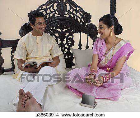 Bengali couple relaxing on a bed View Large Photo Image Picture - Bengali couple relaxing on a bed . Fotosearch