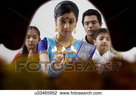 Stock Image - Bengali family doing a puja . Fotosearch