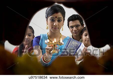 Picture - Bengali family performing a puja . Fotosearch
