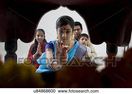 Stock Image - Bengali family performing a puja . Fotosearch