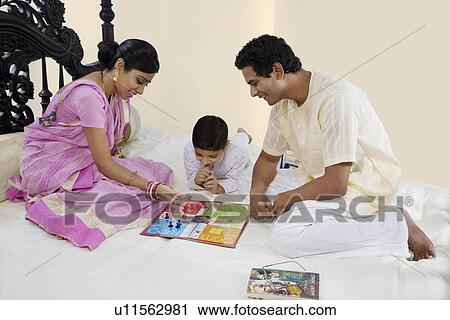 Stock Image - Bengali family playing ludo . Fotosearch