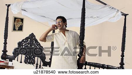 Stock Image - Bengali man talking on a mobile phone . Fotosearch