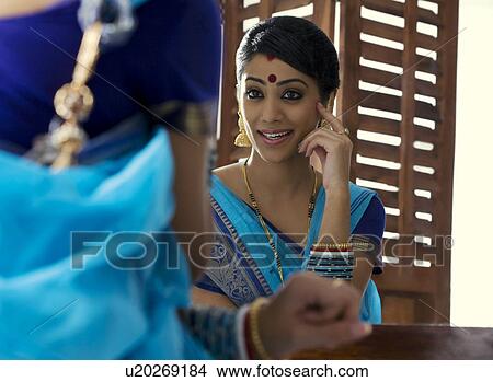Bengali woman admiring herself in a mirror View Large Photo Image Picture - Bengali woman admiring herself in a mirror . Fotosearch