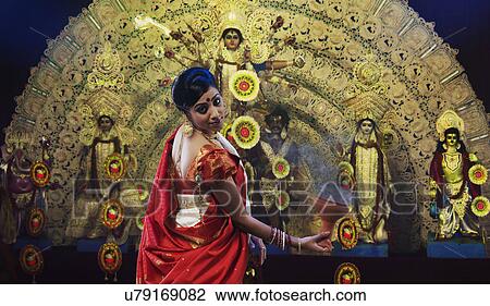 Stock Image - Bengali woman doing a Dhunuchi dance . Fotosearch