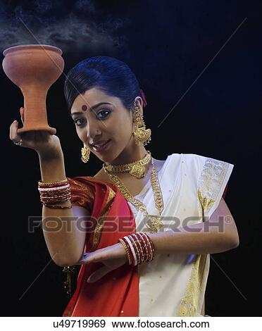 Bengali woman doing a Dhunuchi dance View Large Photo Image Stock Photo - Bengali woman doing a Dhunuchi dance . Fotosearch