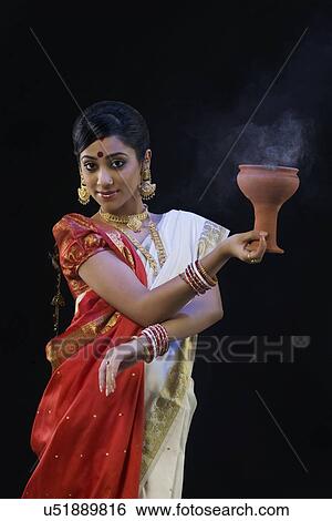 Bengali woman doing a Dhunuchi dance View Large Photo Image Stock Photograph - Bengali woman doing a Dhunuchi dance . Fotosearch