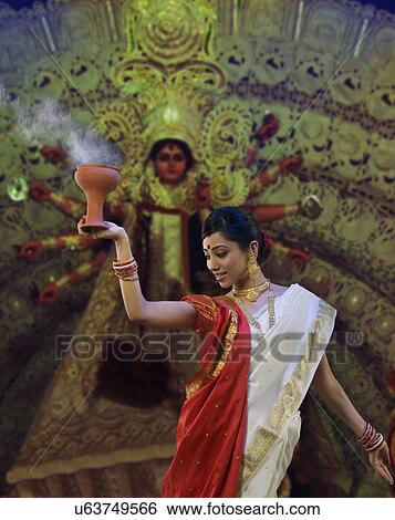 Bengali woman doing a Dhunuchi dance View Large Photo Image Stock Photograph - Bengali woman doing a Dhunuchi dance . Fotosearch
