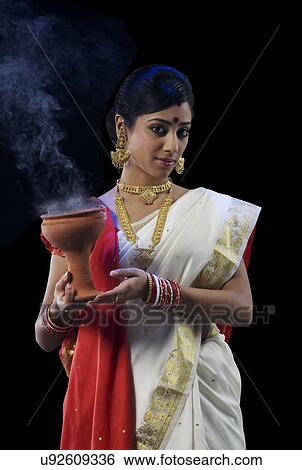 Bengali woman holding a dhunuchi View Large Photo Image Stock Photograph - Bengali woman holding a dhunuchi . Fotosearch