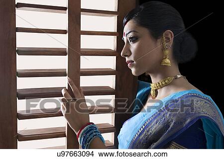 Bengali woman looking out of a window View Large Photo Image Picture - Bengali woman looking out of a window . Fotosearch