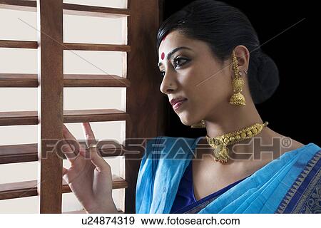 Bengali woman looking out of a window View Large Photo Image Stock Photo - Bengali woman looking out of a window . Fotosearch