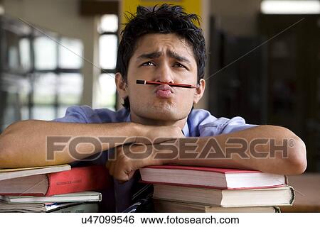 Stock Photograph - Boy balancing a pencil between his nose and mouth . Fotosearch