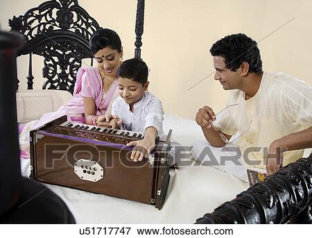 Stock Photo - Boy playing on a harmonium . Fotosearch
