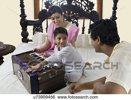 Stock Photograph - Boy playing on a harmonium . Fotosearch