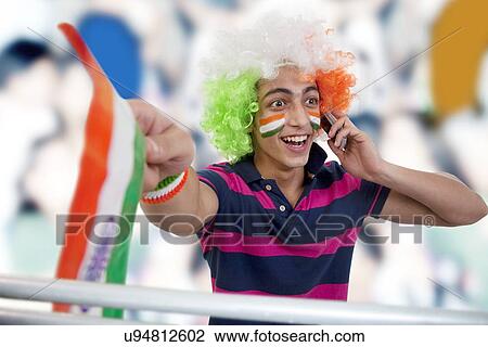 Stock Image - Boy talking on a phone and cheering . Fotosearch