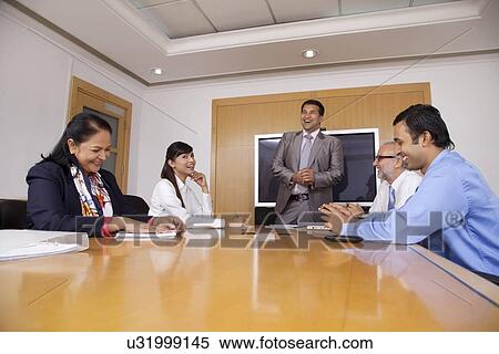 Business executives having a laugh during a meeting View Large Photo Image Stock Photography - Business executives having a laugh during a meeting. Fotosearch
