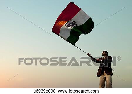 Stock Image - Businessman holding the Indian flag . Fotosearch