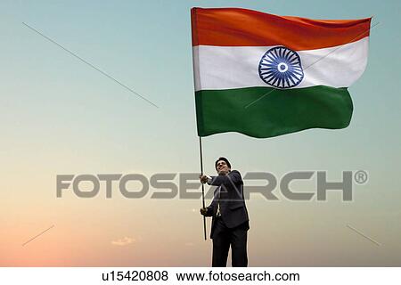 Stock Photo - Businessman holding the Indian flag . Fotosearch