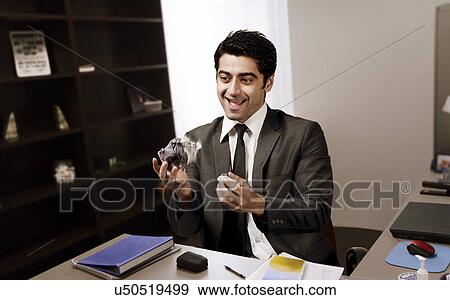 Stock Photo - Businessman juggling paper in the office . Fotosearch
