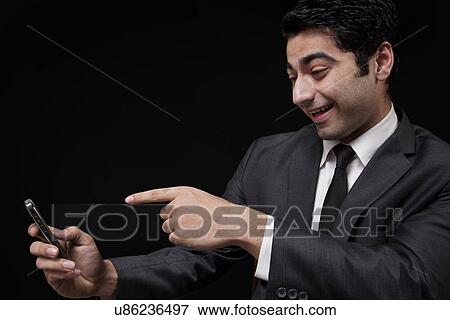 Businessman pointing at his mobile phone View Large Photo Image Stock Photo - Businessman pointing at his mobile phone . Fotosearch