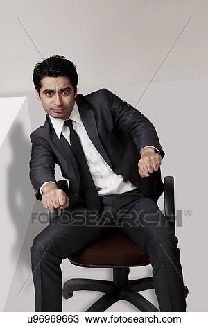 Stock Image - Businessman pretending to ride a motorbike in the office . Fotosearch