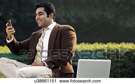Businessman reading a message on a mobile phone View Large Photo Image Stock Image - Businessman reading a message on a mobile phone . Fotosearch