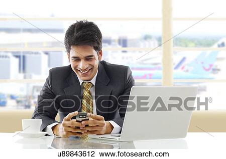 Businessman reading a message on a mobile phone View Large Photo Image Stock Image - Businessman reading a message on a mobile phone . Fotosearch