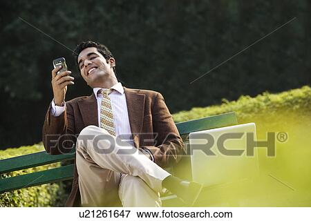 Stock Photo - Businessman reading a message on a mobile phone . Fotosearch