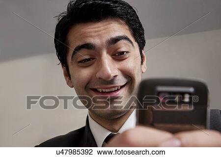 Businessman reading an sms and smiling View Large Photo Image Stock Image - Businessman reading an sms and smiling . Fotosearch