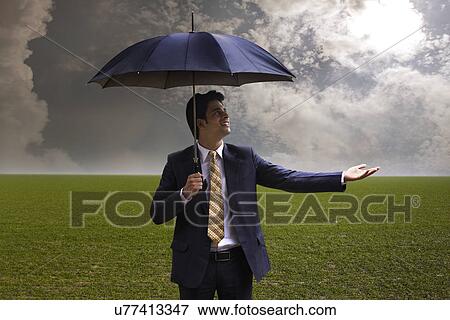 Stock Photo - Businessman with an umbrella . Fotosearch