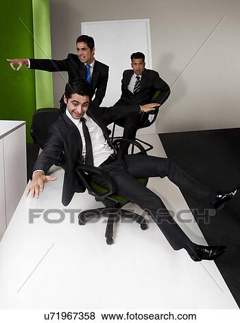 Stock Photo - Businessmen having fun in the office . Fotosearch