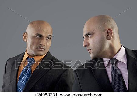 Stock Image - Businessmen looking at each other . Fotosearch