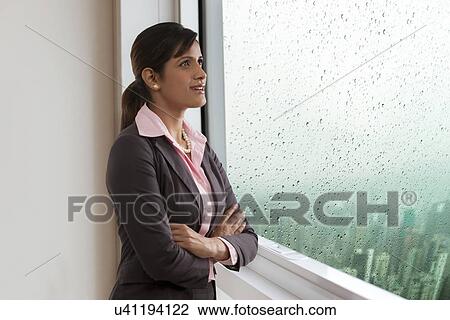 Businesswoman looking out of a window View Large Photo Image Stock Image - Businesswoman looking out of a window . Fotosearch