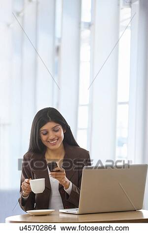 Businesswoman reading an sms on a mobile phone View Large Photo Image Picture - Businesswoman reading an sms on a mobile phone . Fotosearch