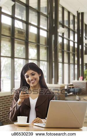 Businesswoman reading an sms on a mobile phone View Large Photo Image Stock Photo - Businesswoman reading an sms on a mobile phone . Fotosearch