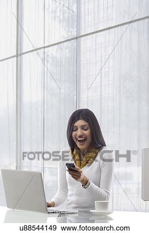 Stock Photo - Businesswoman reading an sms on a mobile phone . Fotosearch