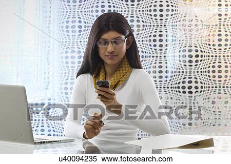 Stock Photography - Businesswoman reading an sms on a mobile phone . Fotosearch
