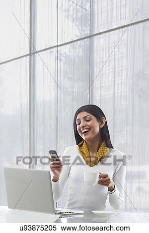 Stock Photography - Businesswoman reading an sms on a mobile phone . Fotosearch