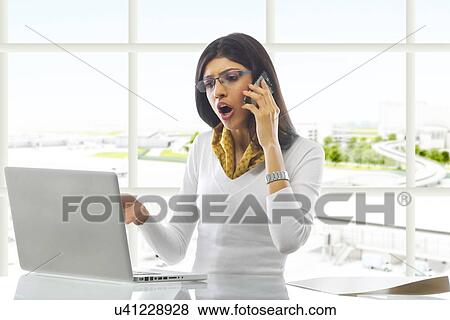 Businesswoman talking on a mobile phone View Large Photo Image Stock Photo - Businesswoman talking on a mobile phone . Fotosearch