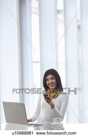 Stock Image - Businesswoman with a mobile phone . Fotosearch
