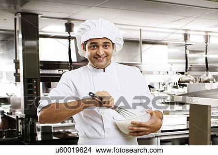 Picture - Chef beating dough in a bowl . Fotosearch