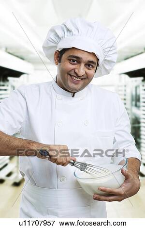 Chef beating dough in a bowl View Large Photo Image Stock Photo - Chef beating dough in a bowl . Fotosearch