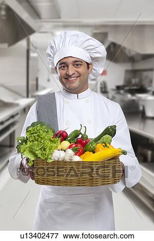 Stock Photo - Chef carrying a basket of fresh vegetables . Fotosearch