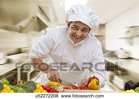 Stock Photo - Chef cutting vegetables in the kitchen . Fotosearch