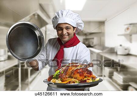 Chef holding a tray of roast chicken View Large Photo Image Stock Image - Chef holding a tray of roast chicken . Fotosearch
