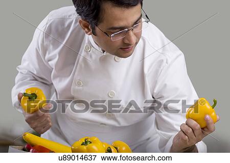 Chef inspecting yellow bell peppers View Large Photo Image Stock Photo - Chef inspecting yellow bell peppers . Fotosearch