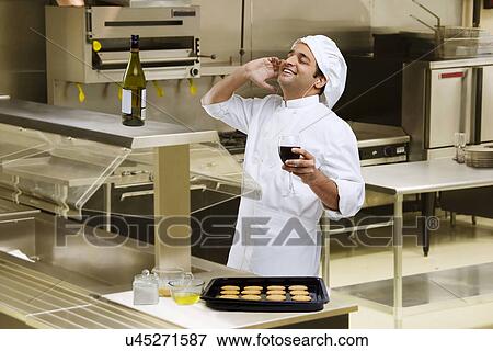 Stock Photo - Chef listening to music while holding a glass of wine . Fotosearch