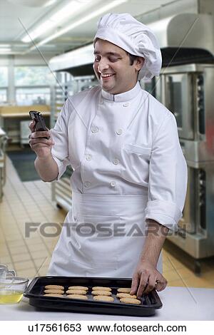 Chef reading an sms View Large Photo Image Stock Image - Chef reading an sms . Fotosearch