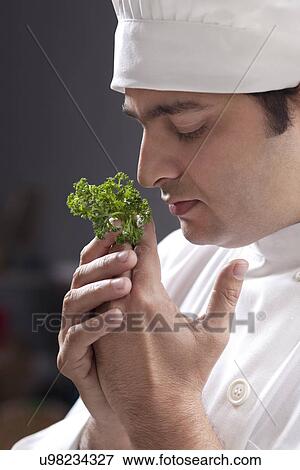 Stock Photo - Chef smelling some herbs . Fotosearch